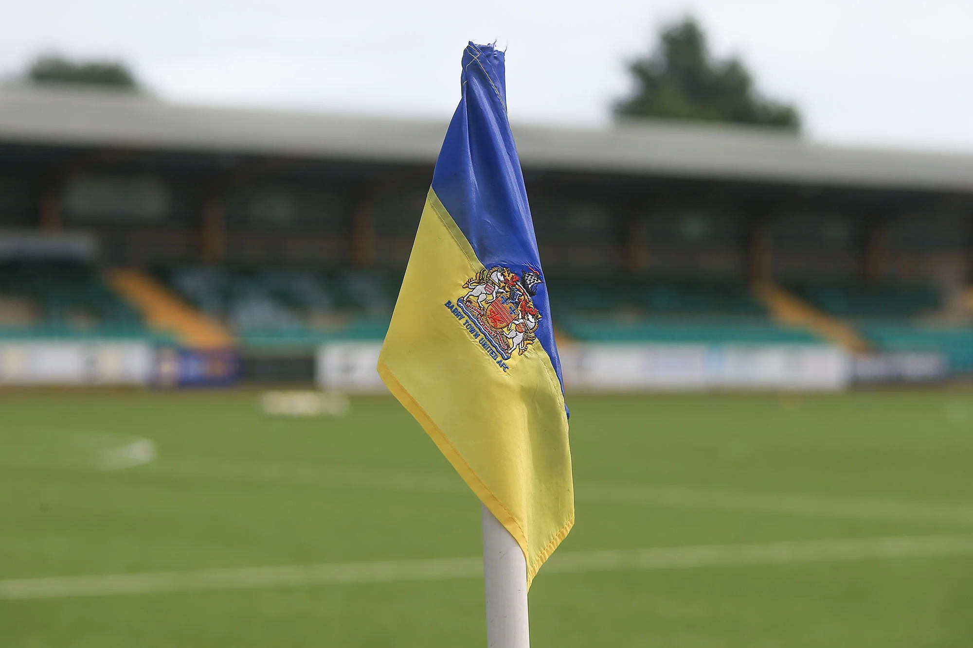 The yellow-and-blue Barry Town corner flag at Jenner Park